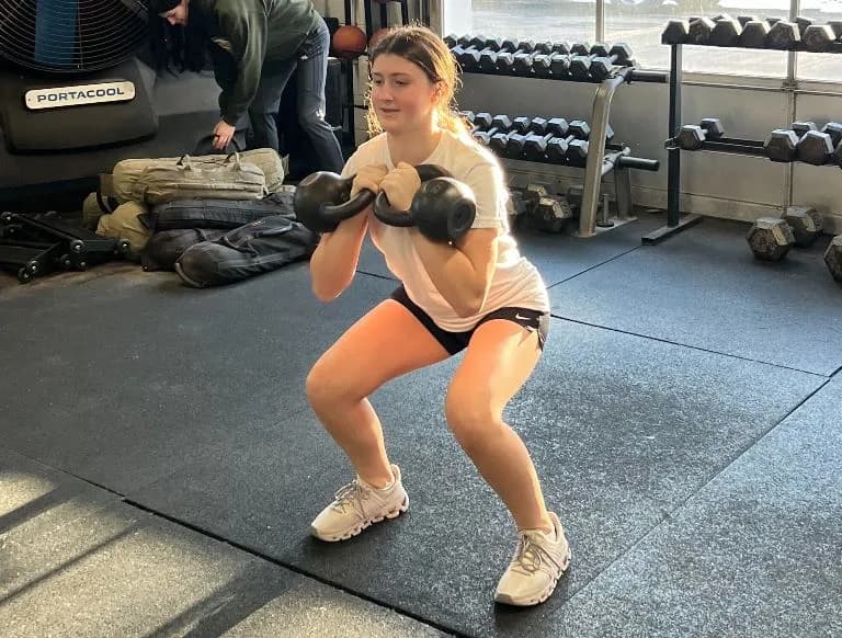 Teen athlete doing a kettlebell goblet squat on the NEPA Fit Club floor